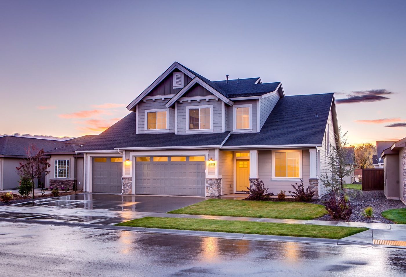 Suburban home with a clean charcoal asphalt-shingle roof at dusk