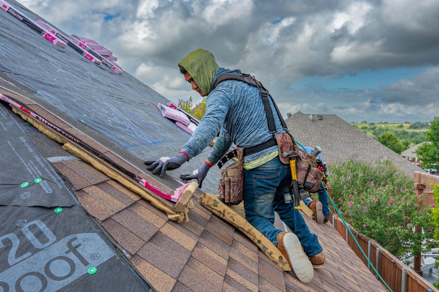 Roofers installing asphalt shingles on a residential roof